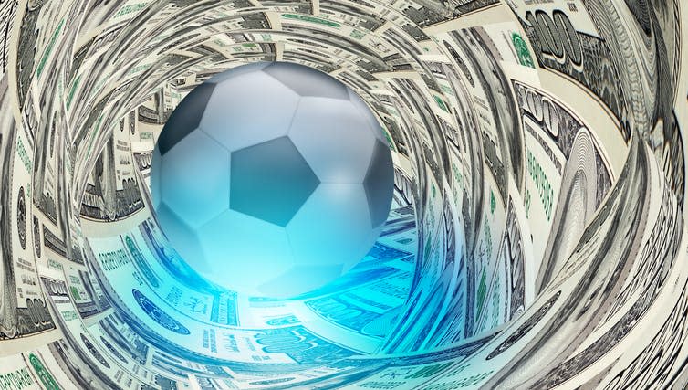 A football surrounded by dollar bills.