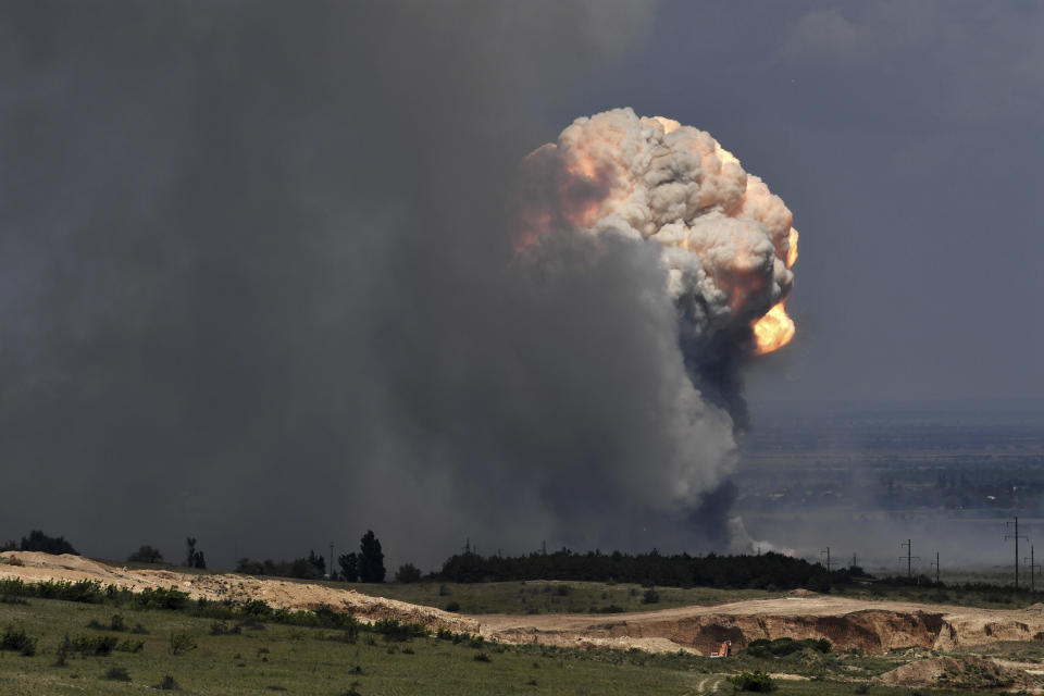 A plume of smoke rises over an ammunition depot where explosions occurred at the facility in Kirovsky district in Crimea, Wednesday, July 19, 2023. Russian emergency officials in Crimea said more than 2,200 people were evacuated from four villages because of a fire at a military facility. The blaze forced the closure of an important highway, according to Sergey Aksyonov, the Moscow-appointed head of the peninsula. He didn't specify a cause for the fire at the facility in Kirovsky district. (Viktor Korotayev/Kommersant Publishing House via AP)