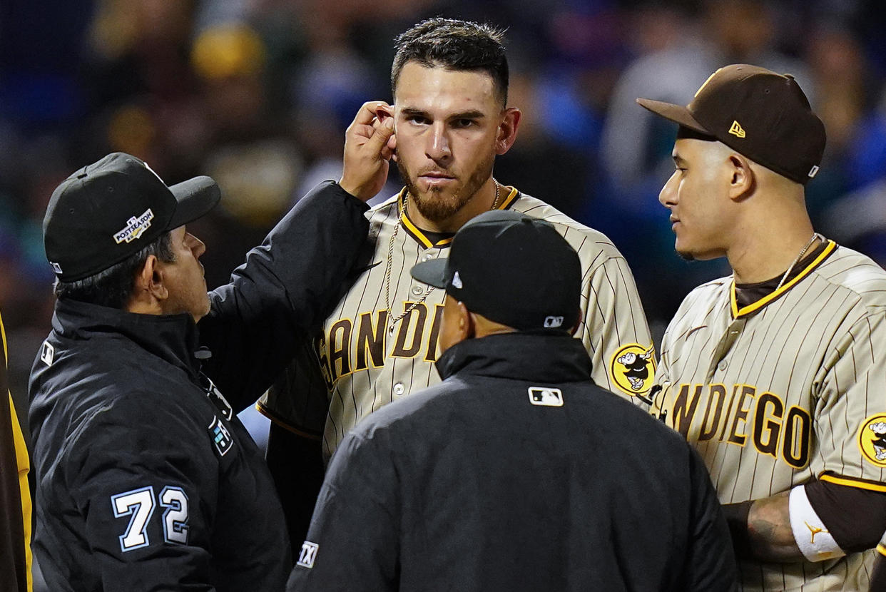 Umpire Alfonso Marquez (72) checks for substances behind the ears of San Diego Padres starting pitcher Joe Musgrove (44) during the sixth inning of Game 3 of a National League wild-card baseball playoff series against the New York Mets, Sunday, Oct. 9, 2022, in New York. / Credit: Frank Franklin II / AP