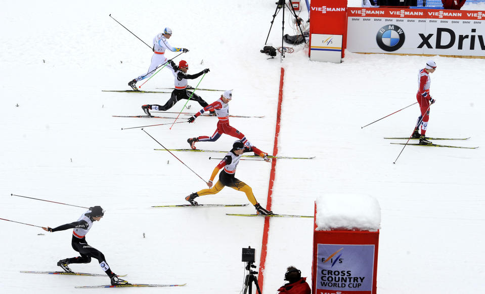 Winner Ola Vigen Hattestad of Norway has already crossed the finish line as second placed Eirik Brandsdal of Norway, and third placed Josef Wenzl of Germany, sprint on the finish line of a cross country men's World Cup sprint, in Dobbiaco, Italy, Sunday, Feb. 2, 2014. (AP Photo/Elvis Piazzi)