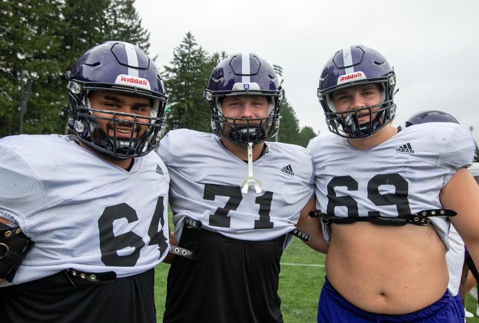 Holy Cross offensive linemen, from left, Eric Schon, Luke Newman and C.J. Hanson share a moment at practice Wednesday.
