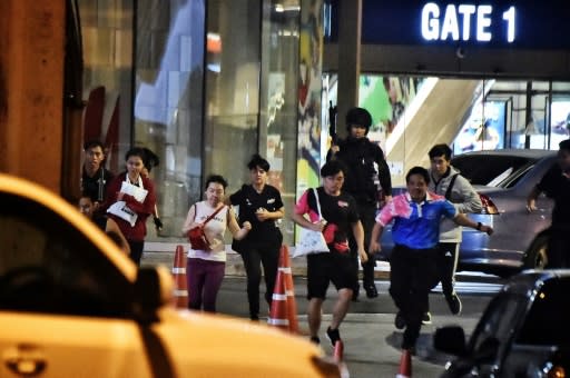 Rescued by Thai commandos, people run from the shopping mall in Nakhon Ratchasima city