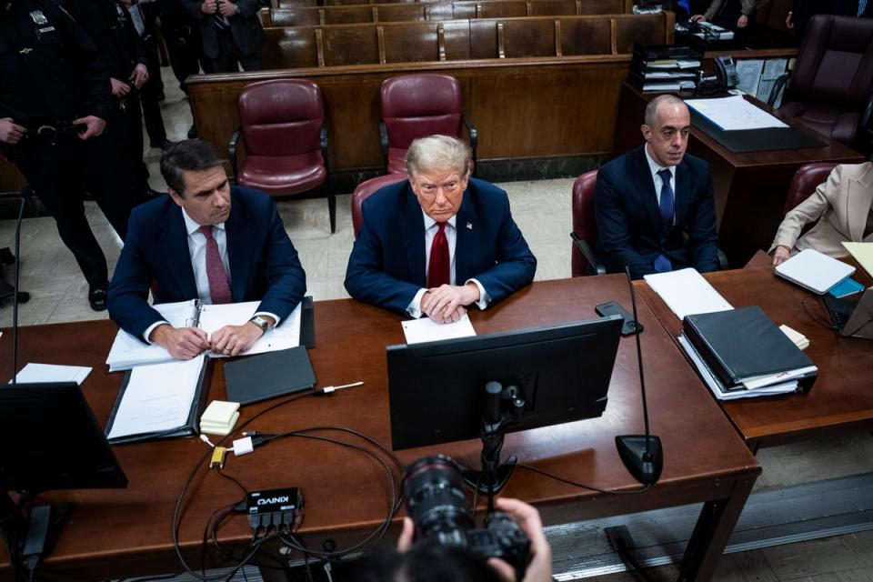 Donald Trump toma asiento en la mesa de la defensa junto a sus abogados en el primer día de su juicio por soborno (AP)