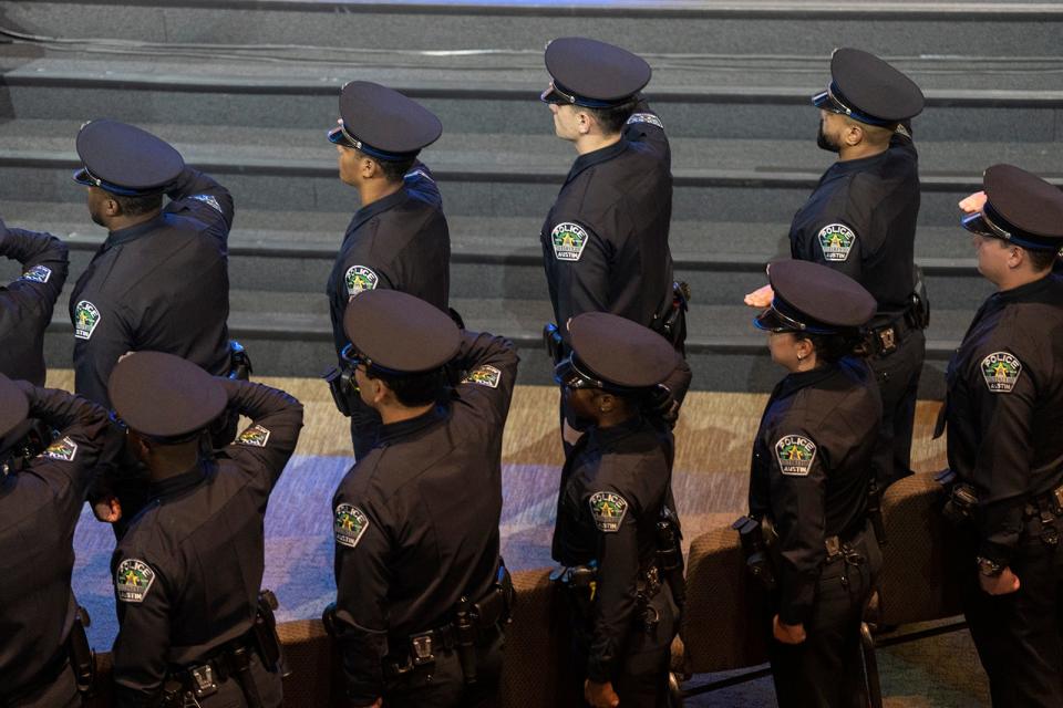 Graduating cadets salute the American flag during the Austin Police Department's commencement ceremony at Bannockburn Church in South Austin on Jan. 5. A judge's decision about a type of confidential police file will be a key to the city's contract negotiations with the officers' union.