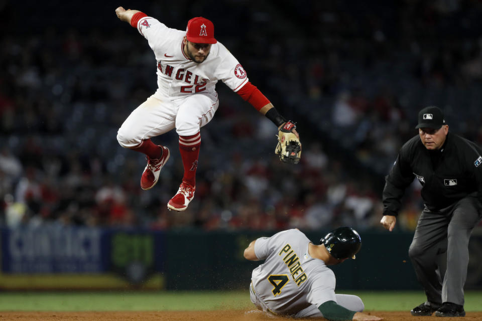 Oakland Athletics' Chad Pinder slides under Los Angeles Angels second baseman David Fletcher for a stolen base during the sixth inning of a baseball game in Anaheim, Calif., Saturday, Sept. 18, 2021. (AP Photo/Alex Gallardo)