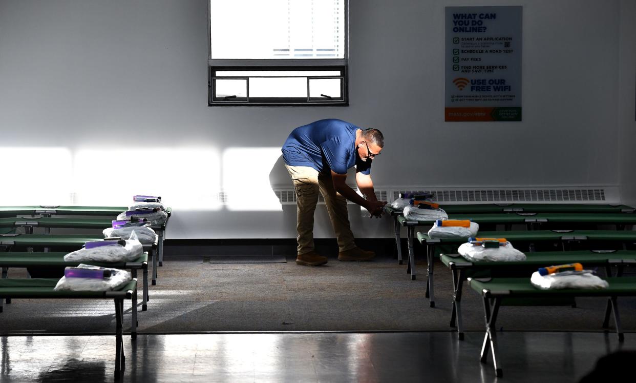 Case worker Frankie Rivera walks between rows of cots as he numbers each one at the RMV winter shelter Monday.