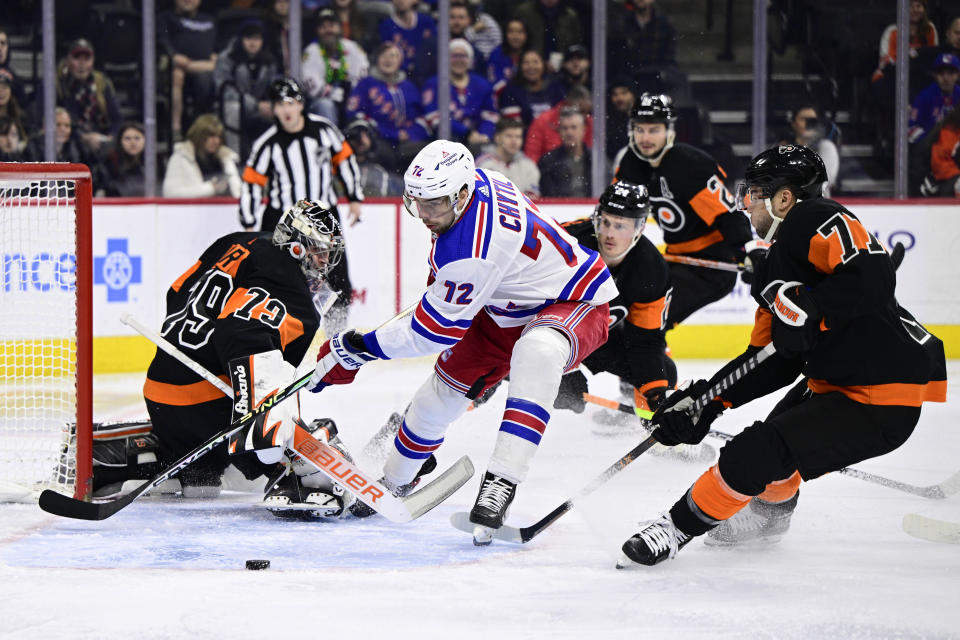 New York Rangers' Filip Chytil, center, races Philadelphia Flyers' Tony DeAngelo, right, for a loose puck during the first period of an NHL hockey game, Saturday, Dec. 17, 2022, in Philadelphia. (AP Photo/Derik Hamilton)
