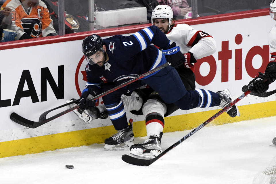 Ottawa Senators' Mark Kastelic (47) works against Winnipeg Jets' Dylan Demelo (2) during the second period of an NHL hockey game Tuesday, Dec. 20, 2022, in Winnipeg, Manitoba. (Fred Greenslade/The Canadian Press via AP)