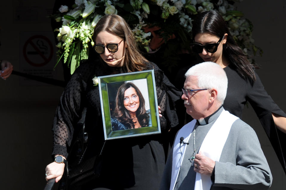 Sarah Ristevski, daughter of Karen Ristevski, carries a photo of her mother at the funeral.