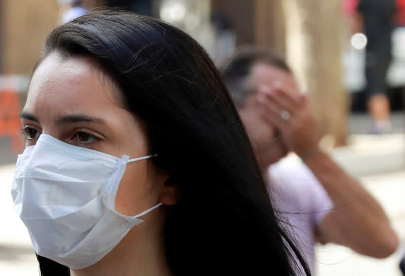 A woman walks as she wears a protective mask during the coronavirus disease (COVID-19) outbreak in downtown Porto Alegre