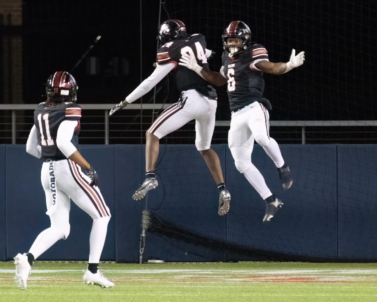 McKinley’s Shaukeer Hatcher (6) celebrates his pick six with Robert Brown (24) and Keith Quincy (11), which gave McKinley a 14-0 lead over St. Ignatius in their playoff game Friday, Nov. 3, 2023.
