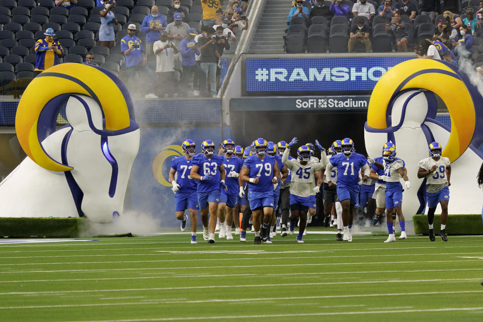 Fans watch as the Los Angeles Rams enter the field during NFL football camp Thursday, June 10, 2021, in Inglewood, Calif. (AP Photo/Marcio Jose Sanchez)