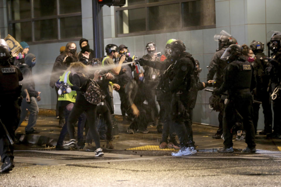 Protesters demanding the end of police violence against Black people are sprayed by police during a demonstration in Portland, Ore., on Wednesday, Sept. 23, 2020. Protesters in Portland hurled Molotov cocktails at officers in Oregon's largest city during a demonstration over a Kentucky grand jury's decision to not indict officers in the fatal shooting of Breonna Taylor, police said Thursday. (Mark Graves/The Oregonian via AP)