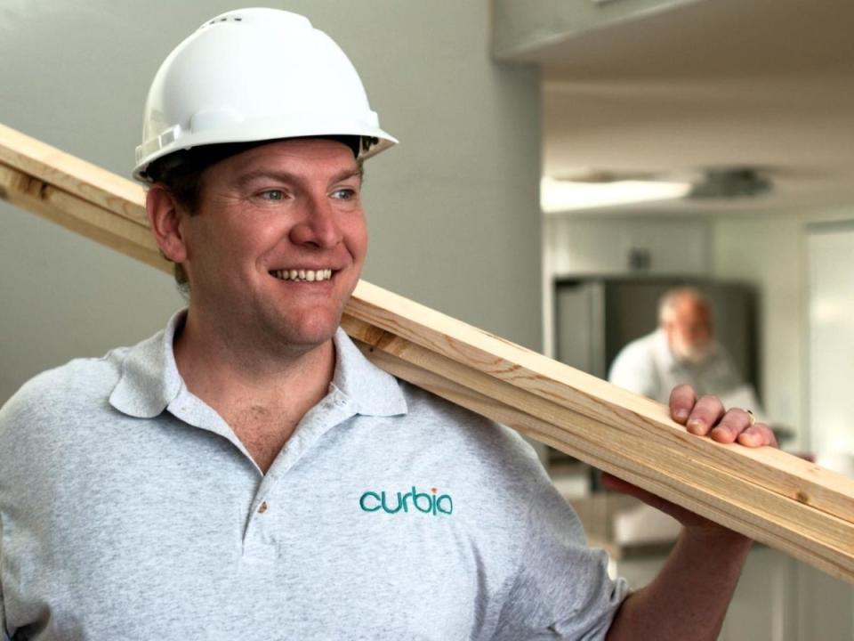 Construction worker holding wood