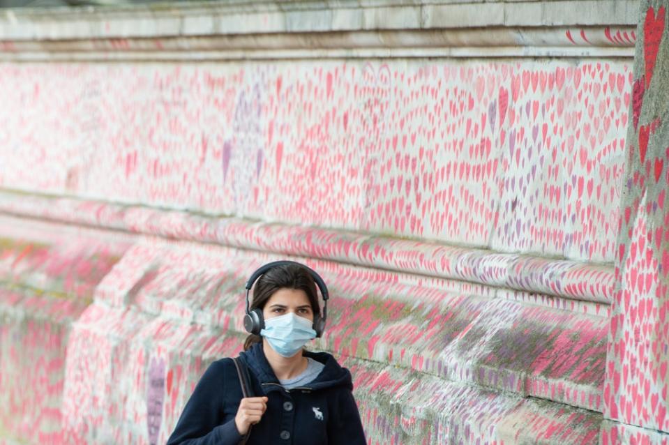 A woman walks past the Covid memorial wall in Westminster, London (Dominic Lipinski/PA) (PA Wire)