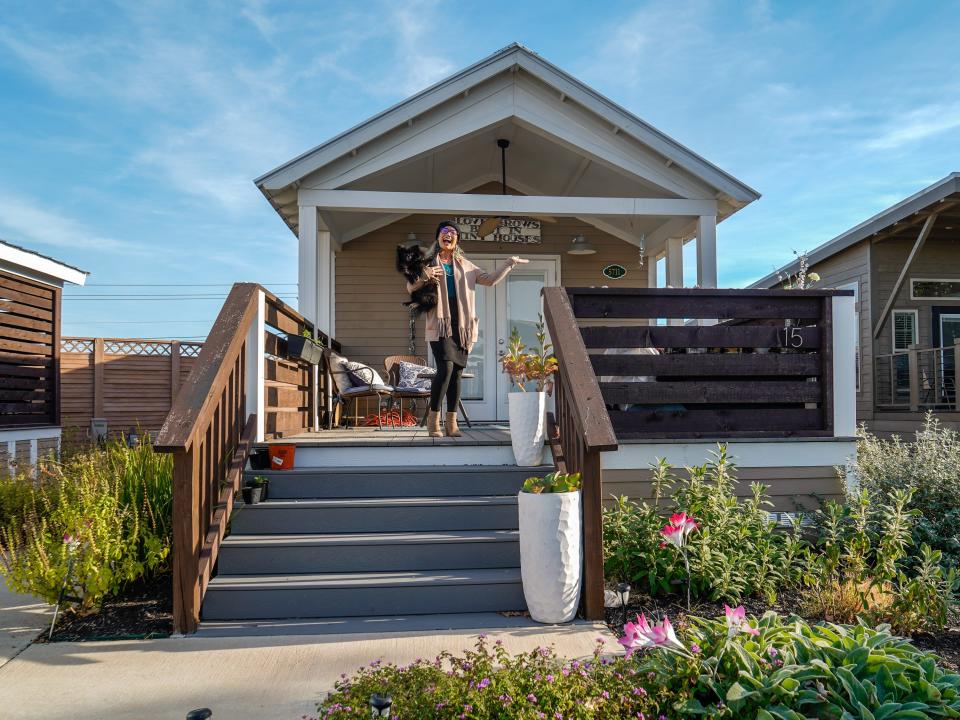 A tiny home dweller with her dog in front of her house