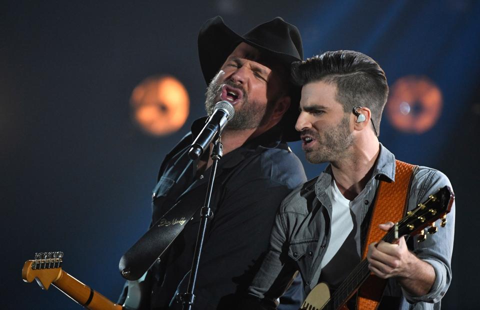 Garth Brooks performs "Ask Me How I Know" with Mitch Rossell, who co-wrote the song, during the CMA Awards Wednesday, Nov. 8, 2017 at Bridgestone Arena in Nashville, Tenn.