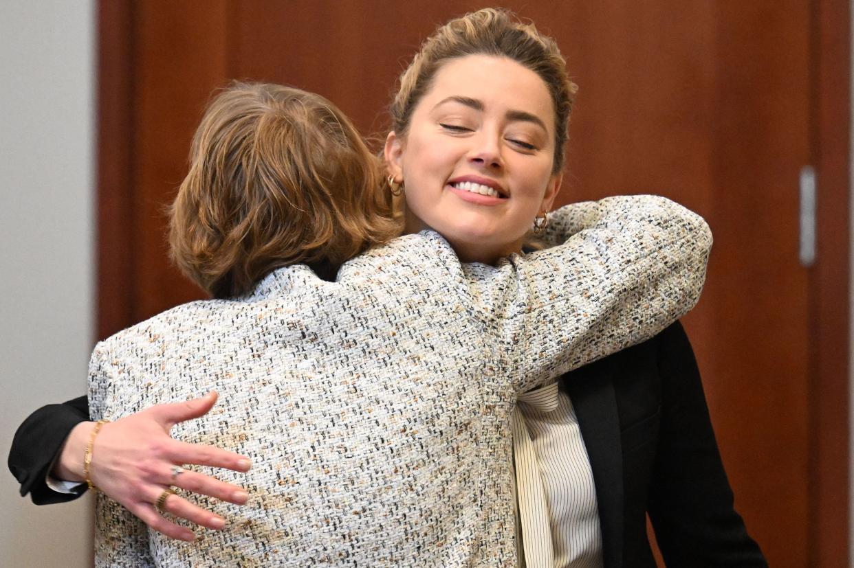 U.S. actress Amber Heard (R) embraces attorney Elaine Bredehoft during a hearing at the Fairfax County Circuit Courthouse in Fairfax, Virginia on April 19, 2022.