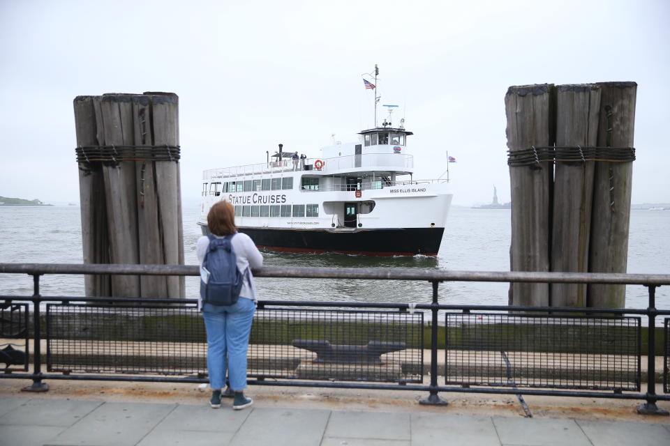 A tourist photographs a tour boat in New York Harbor. (Photo: Gordon Donovan/Yahoo News)