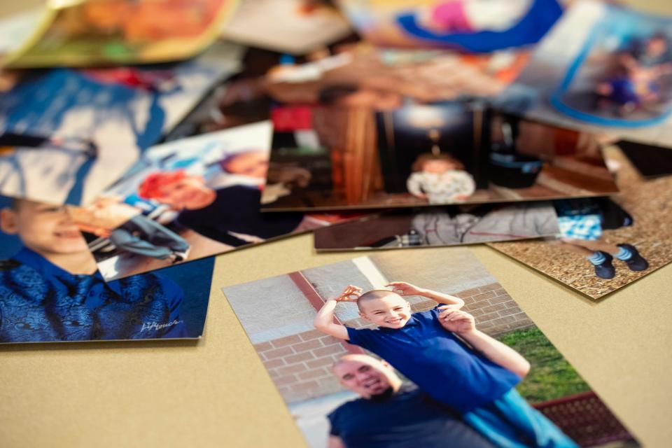 A photograph of Brian Loomis and his father, Mike Walp, is seen as Loomis' grandmother, Deborah Smith, lays out photographs on a table at Newcomer Cremations, Funerals and Receptions in Columbus on June 6.