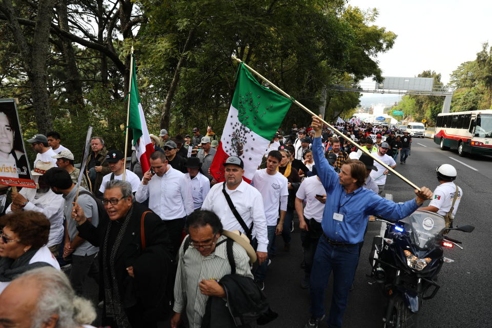 People attend a protest against violence coined “Walk for Peace" as they leave Cuernavaca, Mexico, Thursday, Jan. 23, 2020, with Mexico City as their destination. Activist and poet Javier Sicilia is leading his second march against violence in Mexico, this time accompanied by members of the LeBaron family, like Julian LeBaron who is at the center of the photograph wearing baseball cap, and plan to reach Mexico's National Palace on Sunday. (AP Photo/Eduardo Verdugo)