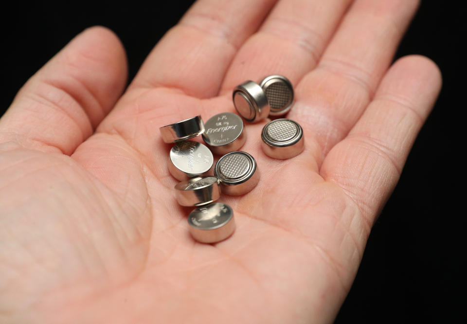 A person holds a pile of Energizer LR44/A76 Alkaline 1.5v batteries in their hand as families are being urged to be aware of the danger of button batteries. Source: Andrew Matthews