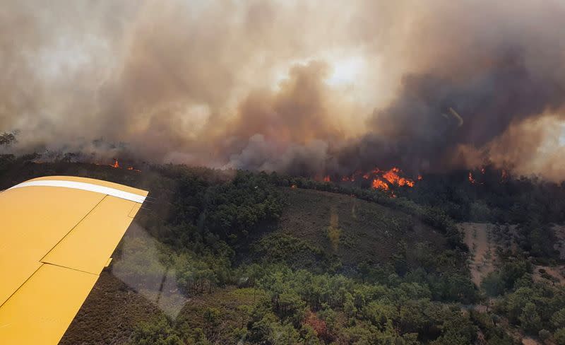 Un avión turco de extinción de incendios sobrevuela un incendio forestal que arde en la isla de Rodas, Grecia.