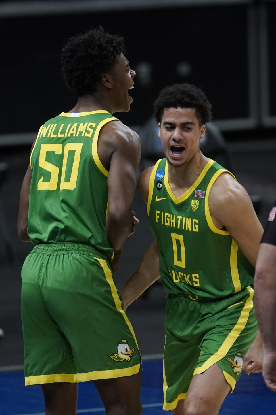 Oregon forward Eric Williams Jr. (50) and Will Richardson (0) celebrate a basket during the first half of a men's college basketball game in the second round of the NCAA tournament at Bankers Life Fieldhouse in Indianapolis, Monday, March 22, 2021. (AP Photo/Paul Sancya)