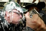 Saskatchewan Premier Brad Wall sips out of the Grey Cup as beer is poured over him in the locker room after the Saskatchewan Roughriders defeated the Hamilton Tiger-Cats to win the CFL's 101st Grey Cup championship football game in Regina, Saskatchewan November 24, 2013. REUTERS/Todd Korol (CANADA - Tags: SPORT FOOTBALL)