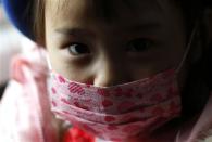 A girl wearing a mask sits in a school bus heading to the Emporium kindergarten in Koriyama, west of the tsunami-crippled Fukushima Daiichi nuclear power plant, Fukushima prefecture February 28, 2014. REUTERS/Toru Hanai