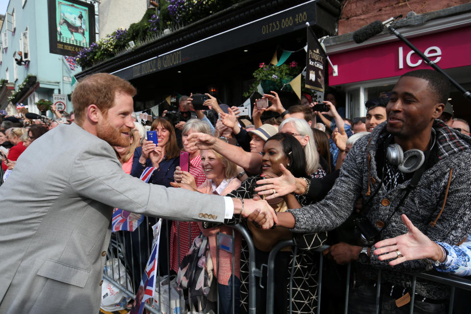 Prince Harry shakes hands with a fan outside Windsor Castle. (Photo: Jonathan Brady/pool via Reuters)