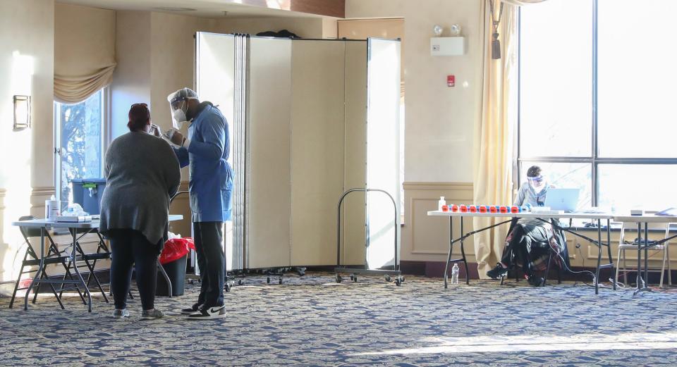 Dexton Cummings, center, of New York City, administers a COVID-19 antigen test at Patriot Hills Golf Course in Stony Point on Tuesday, January 4, 2022. 