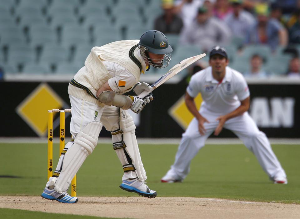 The ball catches inside the vest of Australia's Chris Rogers (L) as England's captain Alastair Cook stands at first slip during the first day's play of the second Ashes test cricket match in Adelaide December 5, 2013.
