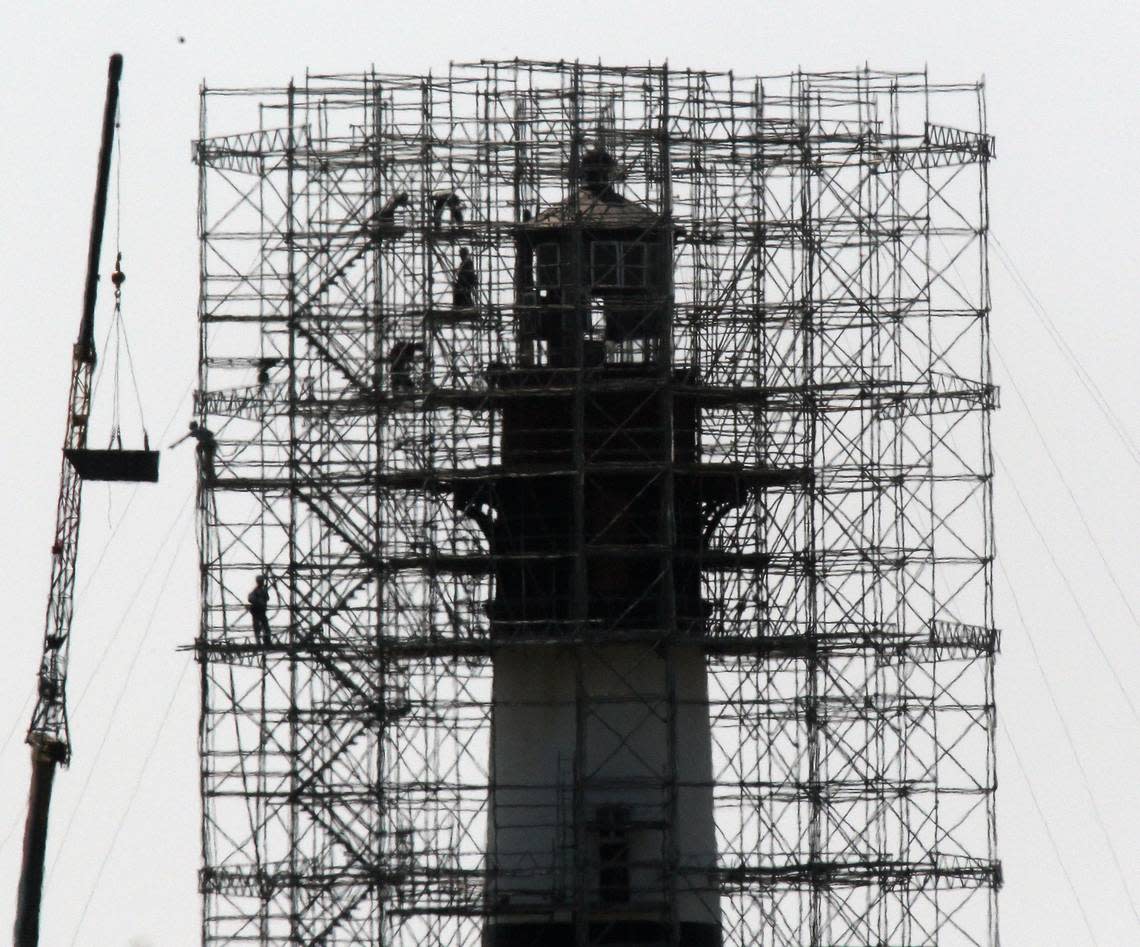 Getting ready: Workers remove sheet metal and wood from the Bodie Island lighthouse, which is under renovation, as Hurricane Earl approaches the Outer Banks Wednesday. Forecasters say even an offshore storm track would bring wind gusts of up to 80 mph to the coast.