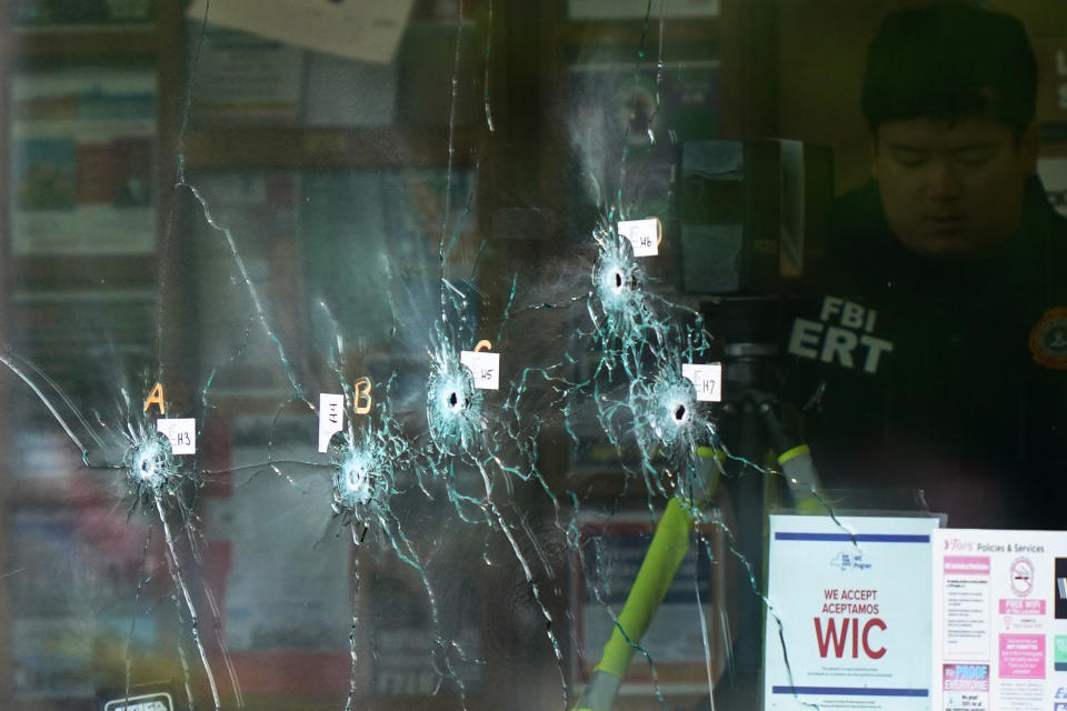 FILE - Bullet holes are seen in a window as an investigator works at the scene of a fatal shooting at a supermarket in Buffalo, N.Y., Monday, May 16, 2022. A white man is accused of shooting several people days earlier at the Tops Friendly Market in a predominantly Black neighborhood of Buffalo. (AP Photo/Matt Rourke, File)