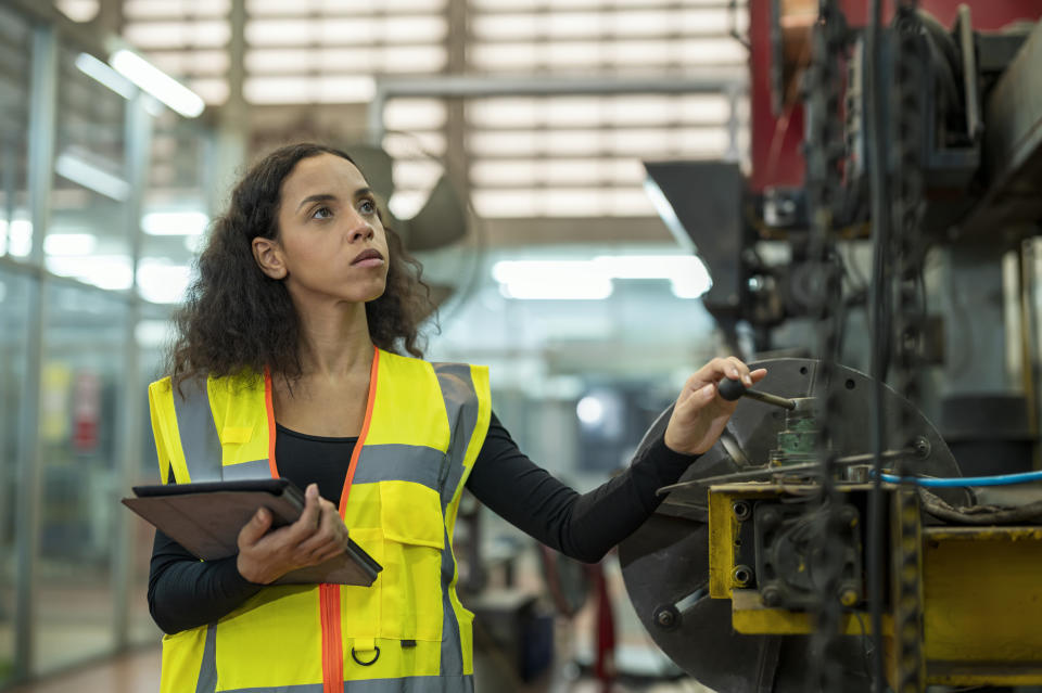 Una ingeniera latina verifica el progreso de la producción en una fábrica. Las mujeres latinas con licenciatura ganan 61 centavos por cada dólar que gana un hombre blanco, dice el NWLC. (Getty Images)