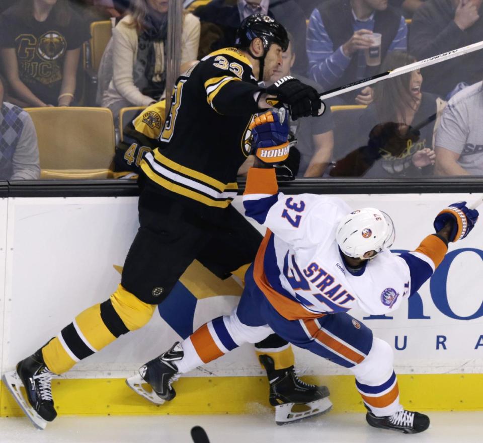 New York Islanders defenseman Brian Strait (37) collides with New York Islanders&#39; Zdeno Chara during the first period of an NHL hockey game in Boston, Thursday, Oct. 23, 2014. Chara left the game during the first period for unspecified reasons, according to team officials. (AP Photo/Charles Krupa)