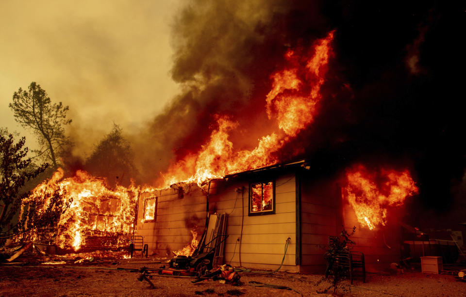 FILE — In this Sept. 23, 2021, file photo flames consume a house near Old Oregon Trail as the Fawn Fire burns about 10 miles north of Redding in Shasta County, Calif. Massive wildfires are making it harder for some California homeowners to get property insurance, pitting the state's insurance commissioner, Ricardo Lara, against the industry in an escalating conflict that will likely extend into 2022's statewide elections. Lara, a Democrat, has ordered the pool, the California Fair Access to Insurance Requirements Plan - also known as the FAIR Plan, to sell more than just fire insurance. (AP Photo/Ethan Swope, File)