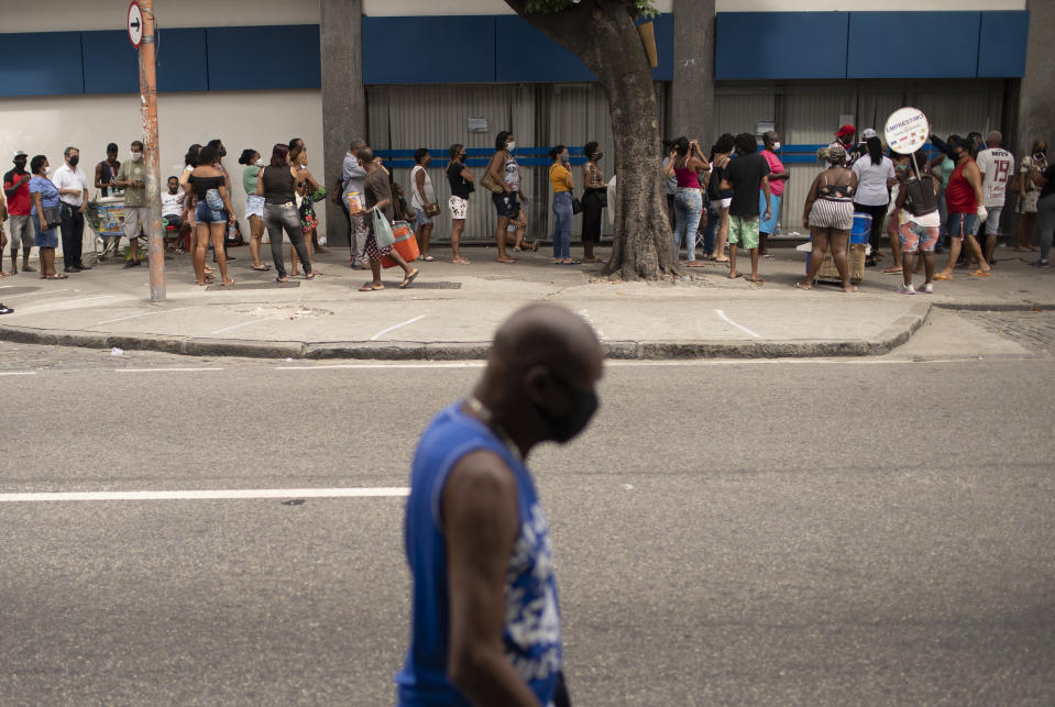 People out of work wait outside a government-run bank having technical problems to distribute their aid money amid the new coronavirus pandemic's affect on the economy in Rio de Janeiro, Brazil, Tuesday, April 28, 2020. (AP Photo/Silvia Izquierdo)