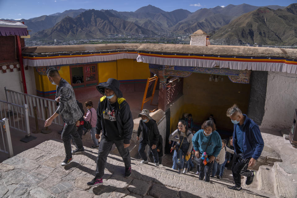 Tourists climb a flight of stairs at the Potala Palace in Lhasa in western China's Tibet Autonomous Region, Tuesday, June 1, 2021. Tourism is booming in Tibet as more Chinese travel in-country because of the coronavirus pandemic, posing risks to the region's fragile environment and historic sites. (AP Photo/Mark Schiefelbein)