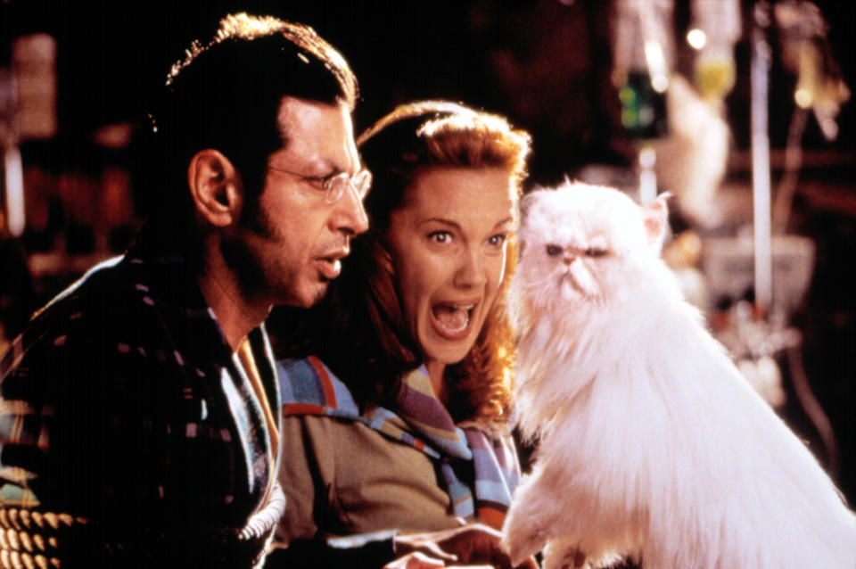 Jeff Goldblum, Téa Leoni, and a white dog in a scene from a film, displaying surprise