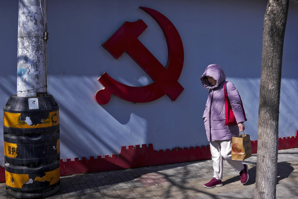 A woman walks by a Communist Party's logo on display near a residential area in Beijing on March 1, 2024. China's efforts to restore confidence and rev up the economy will top the agenda during this month’s meeting of the ceremonial national legislature. (AP Photo/Andy Wong)