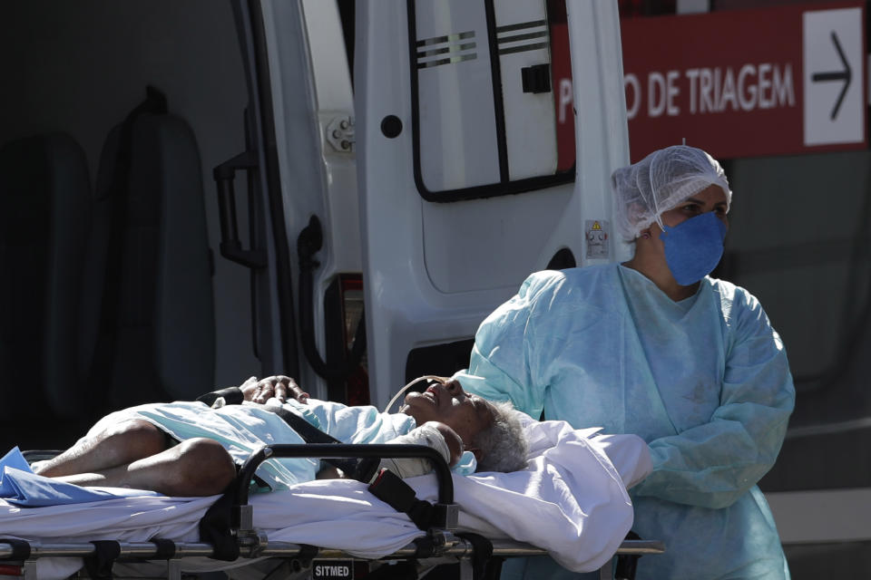 A patient suspected of having COVID-19 is received at the HRAN Hospital in Brasilia, Brazil, Wednesday, March 3, 2021. Brazil dodged the most dire economic forecasts in 2020, but official figures released Wednesday show the COVID-19 pandemic still battered the nation and it continues to dim the outlook for recovery. (AP Photo/Eraldo Peres)