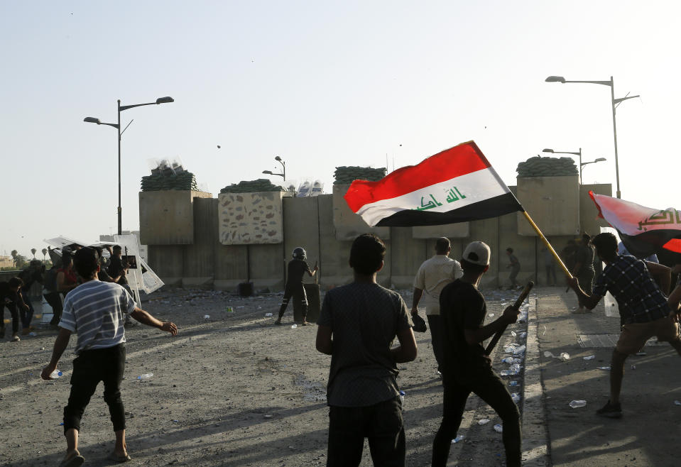 Anti-government protesters throw stones towards security forces during a demonstration in Tahrir Square in Baghdad, Iraq, Wednesday, Sept. 28, 2022. (AP Photo/Hadi Mizban)