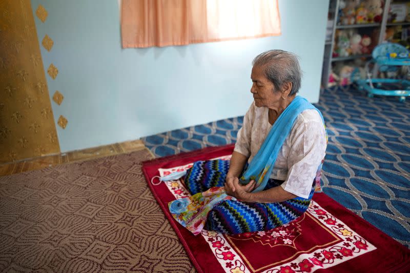 Daw Thein Khin, a 100-year-old woman survivor of the coronavirus disease (COVID-19) prays at her home in Yangon