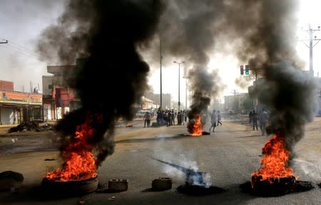 Sudanese protesters use burning tyres to erect a barricade on a street, demanding that the country's Transitional Military Council hand over power to civilians, in Khartoum