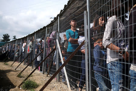 People queue for free food at a makeshift camp for migrants and refugees at the Greek-Macedonian border near the village of Idomeni, Greece, May 11, 2016. REUTERS/Marko Djurica