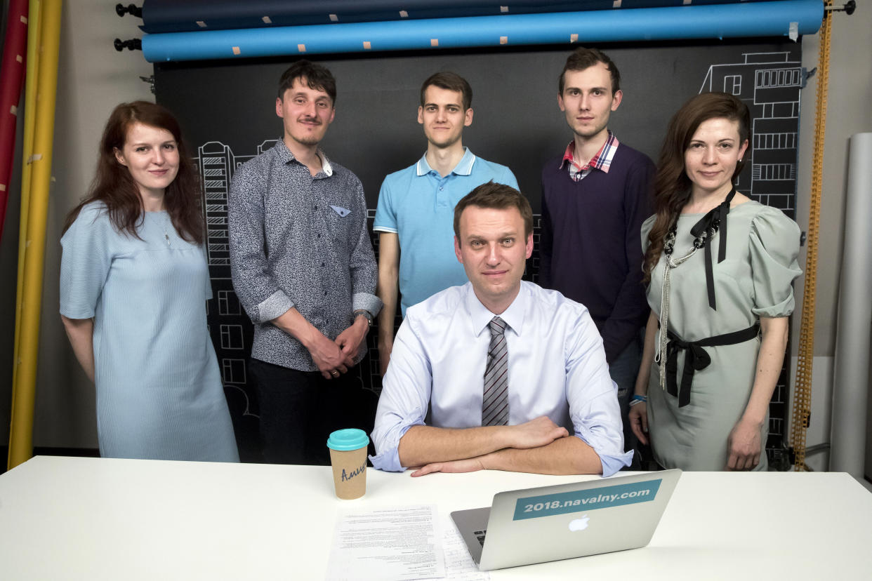 FILE - Russian opposition leader Alexei Navalny, center, and his team, stand from left: Navalny's spokeswoman Kira Yarmysh, live broadcast director Alexei Yakovlev, live broadcast director Artem Guryev, employee of Navalny's Foundation for Fighting Corruption Ilya Pakhomov, and chief of Navally's video operations Oksana Baulina, pose for a picture at the office of the Foundation for Fighting Corruption in Moscow, Russia, on Thursday, May 18, 2017. Blacklisted by state-owned media, Navalny is tapping into the resources of YouTube. The broadcasts have become a key piece of Navalny's strategy to galvanize opposition to President Vladimir Putin and the upper echelons of power that he says are awash in corruption. In a span of a decade, Navalny has gone from the Kremlin's biggest foe to Russia's most prominent political prisoner. Already serving two convictions that have landed him in prison for at least nine years, he faces a new trial that could keep him behind for another two decades. (AP Photo/Pavel Golovkin, File)