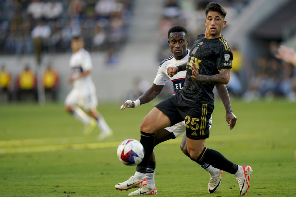 Vancouver Whitecaps midfielder Richie Laryea, rear, passes the ball as Los Angeles FC forward Cristian Olivera defends during the first half of an MLS playoff soccer match Saturday, Oct. 28, 2023, in Los Angeles. (AP Photo/Ryan Sun)