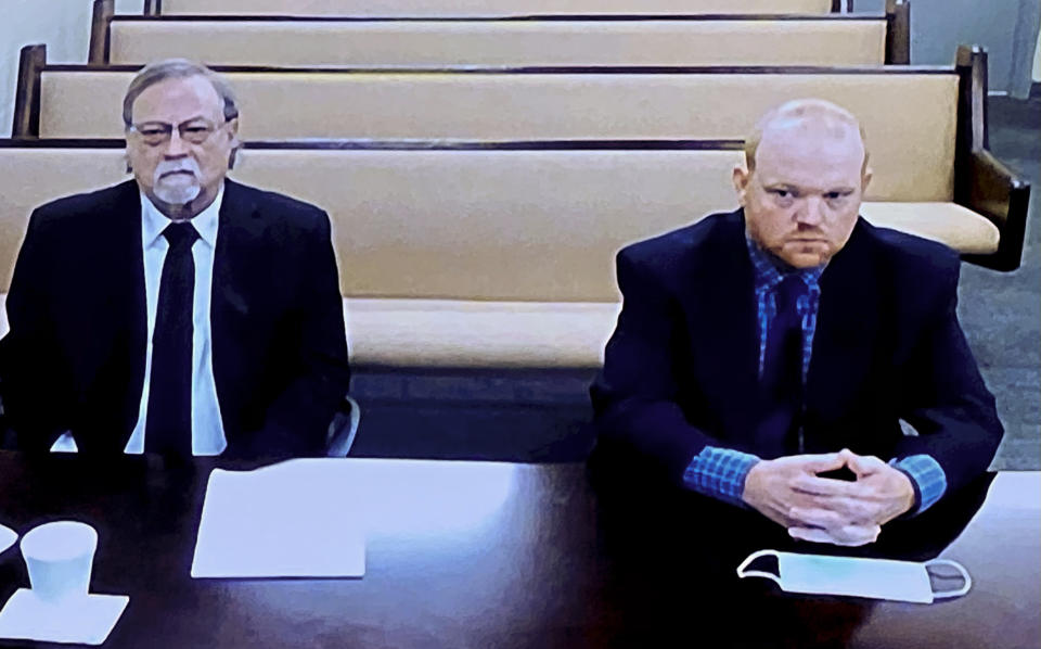 FILE - In this Thursday, Nov. 12, 2020, file image made from video, from left, father and son, Gregory and Travis McMichael, accused in the shooting death of Ahmaud Arbery in Georgia in February 2020, listen via closed circuit TV in the Glynn County Detention Center in Brunswick, Ga., as lawyers argue for bond to be set at the Glynn County courthouse. The judge and attorneys trying to seat a jury in the trial over Ahmaud Arbery's killing aren't finding many jury pool members who are blank slates in the case. (AP Photo/Lewis Levine, File)